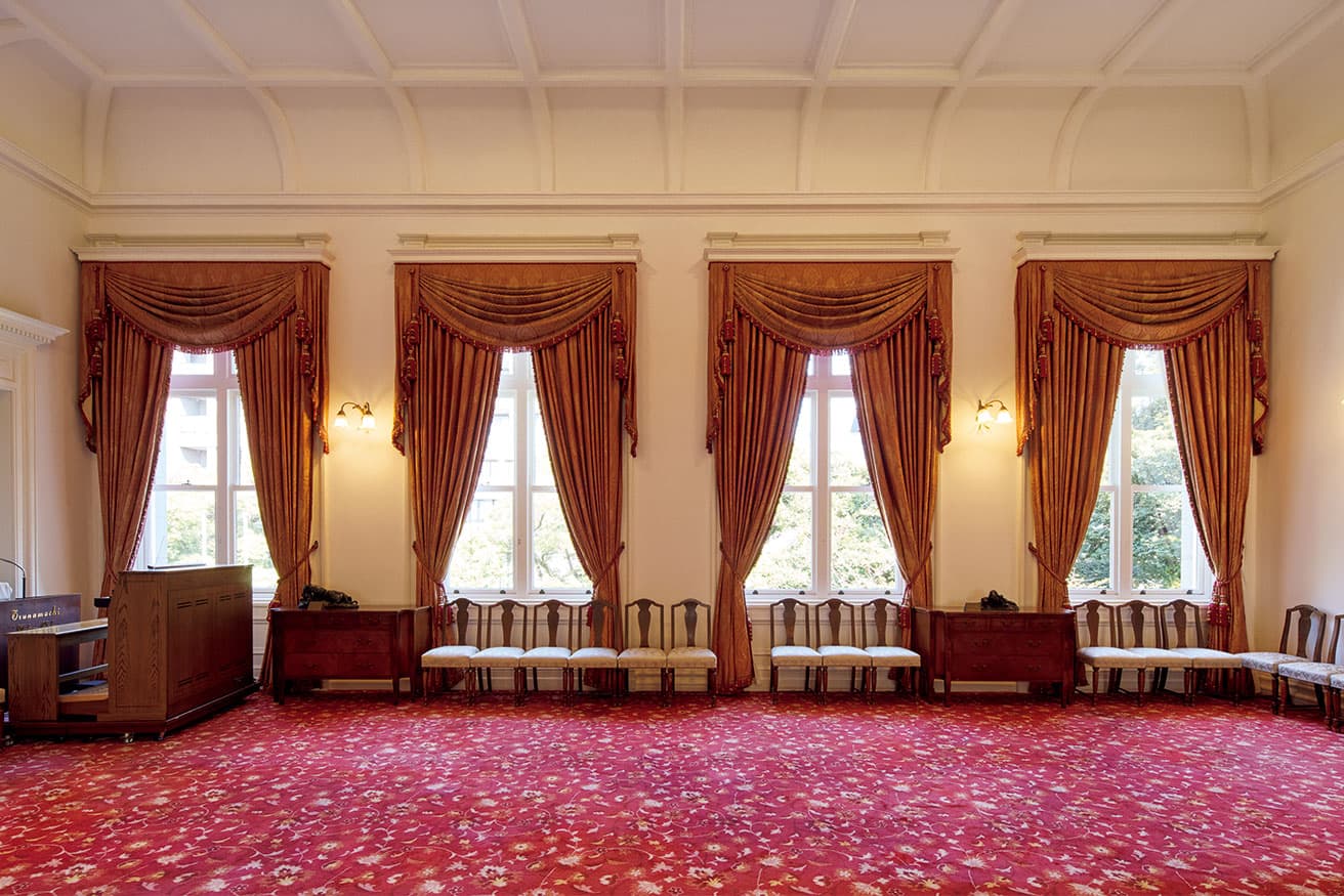 2階東側ホール。洋風のインテリアながら天井を和風の折上格天井としており、これは能舞台(ステージ)を設けていたことによる。