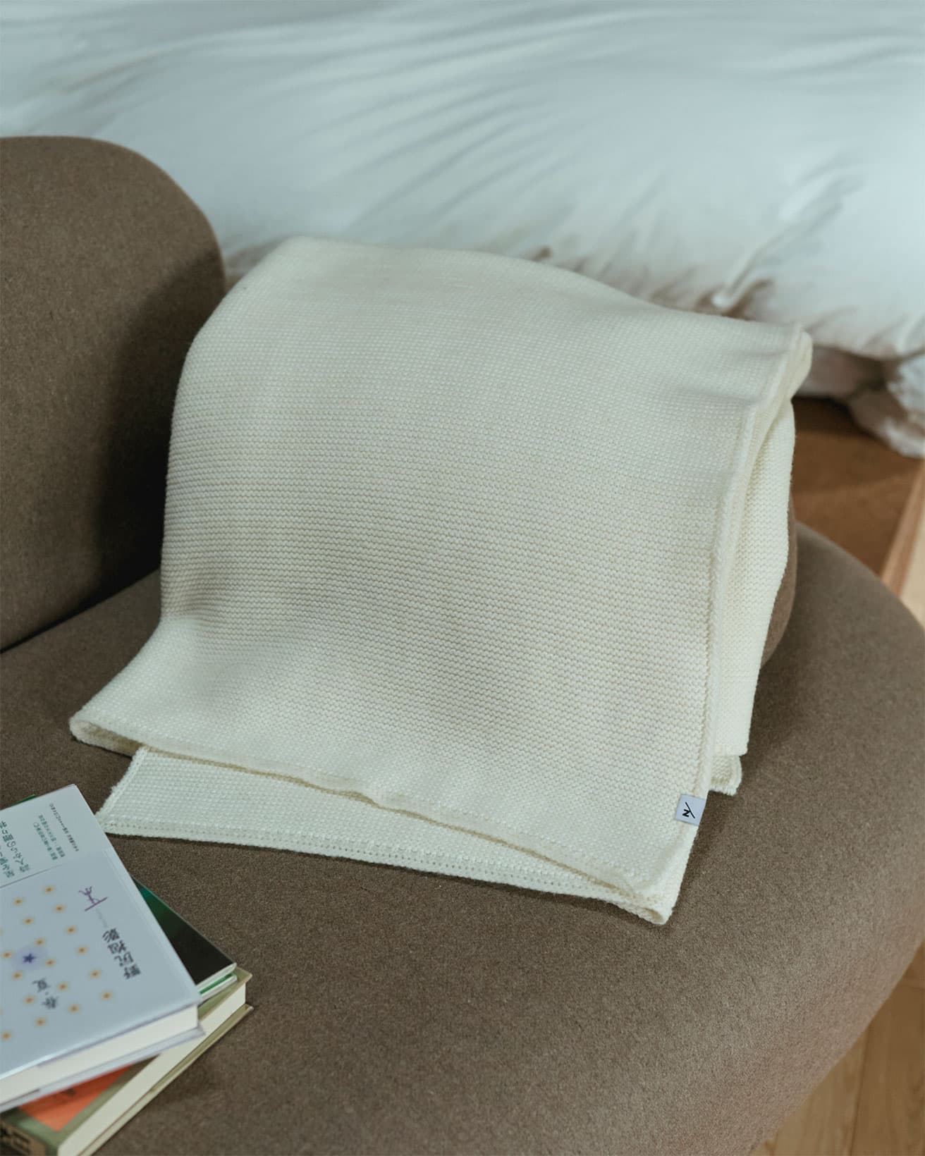 メリノウールに、光電子を練り込んだブランケット。これが2025年11月中、〈SANU 2nd Home 蓼科1st〉の各キャビンに置かれ、実際に光電子のあたたかさを実感できる。