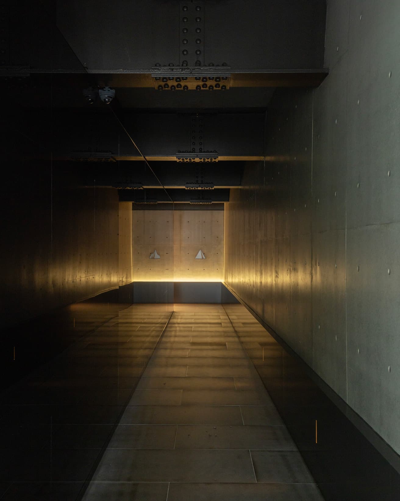 黒い石を貼ったエントランス通路。街の喧騒から離れ、アート空間へと導いてくれる。